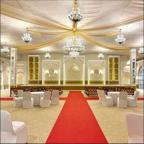 Banquet stage dressed with drapery beneath chandeliers