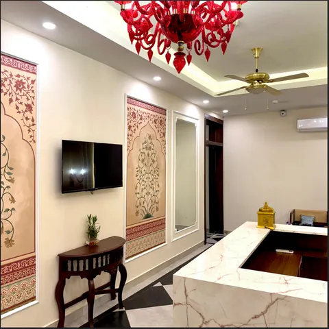 Lobby waiting area with patterned panels and a red chandelier