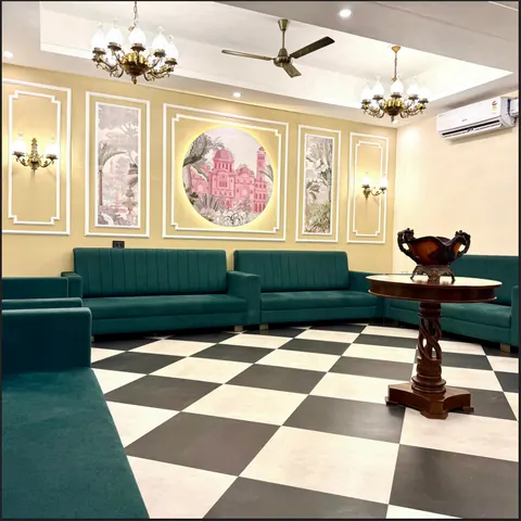 Drawing room with teal sofas and a chequered marble floor