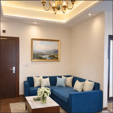 Signature Suite living room with a blue sofa and landscape painting